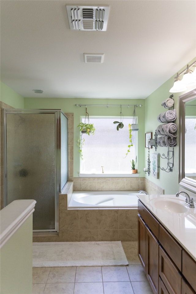 bathroom with tile patterned floors, independent shower and bath, and vanity