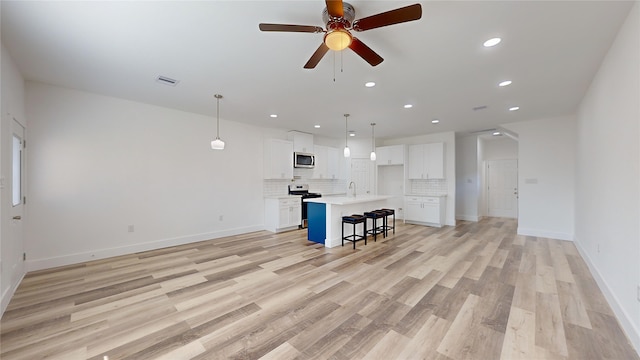 unfurnished living room with ceiling fan and light hardwood / wood-style flooring