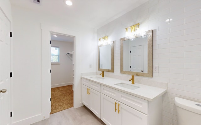 bathroom with vanity, tile walls, and toilet