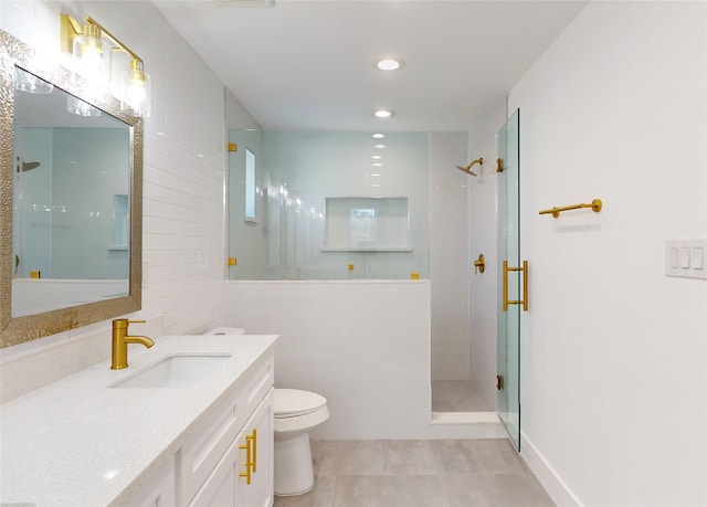 bathroom featuring tile patterned flooring, a shower with shower door, vanity, and toilet