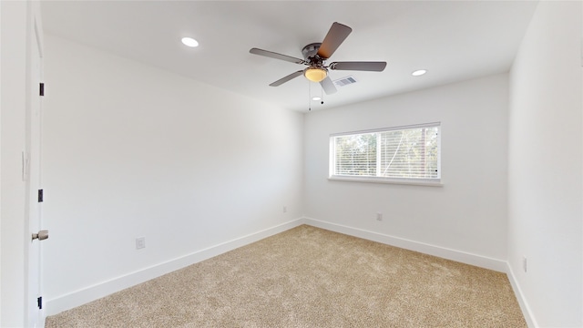 carpeted spare room featuring ceiling fan