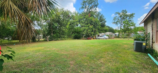 view of yard with central AC and fence