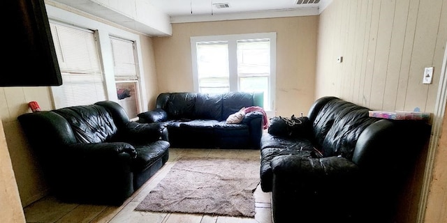 living room featuring visible vents and wooden walls