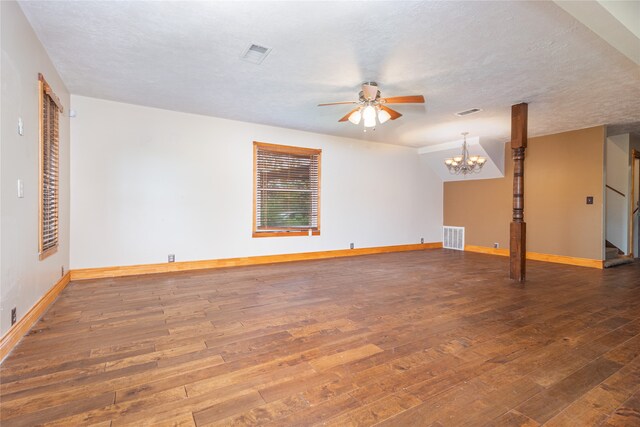 spare room featuring ceiling fan with notable chandelier, a textured ceiling, and dark hardwood / wood-style flooring