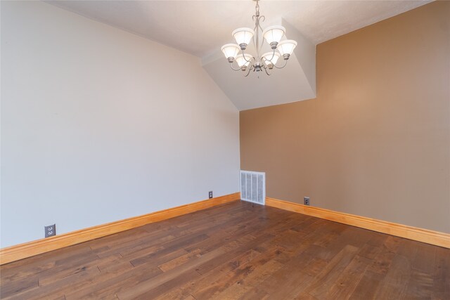 spare room featuring hardwood / wood-style flooring, vaulted ceiling, and a notable chandelier