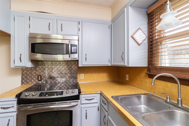 kitchen with white cabinetry, tasteful backsplash, pendant lighting, stainless steel appliances, and sink