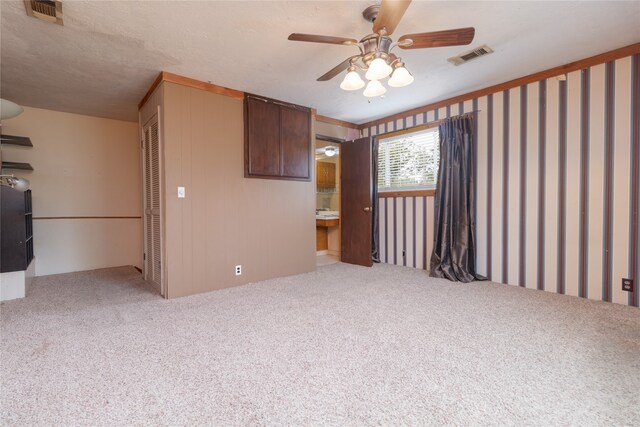 interior space featuring ceiling fan, light colored carpet, and a textured ceiling