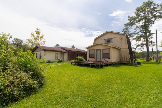 back of house featuring a yard and central AC