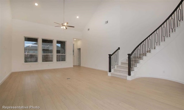 unfurnished living room with light hardwood / wood-style floors, high vaulted ceiling, and ceiling fan