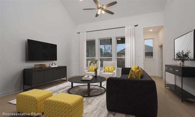 living room with hardwood / wood-style flooring, high vaulted ceiling, and ceiling fan