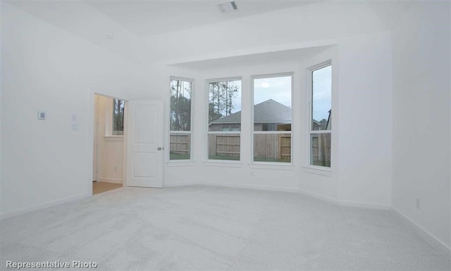 unfurnished room with carpet floors, visible vents, and baseboards