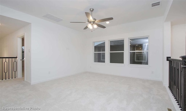 spare room featuring light carpet, baseboards, visible vents, and a ceiling fan