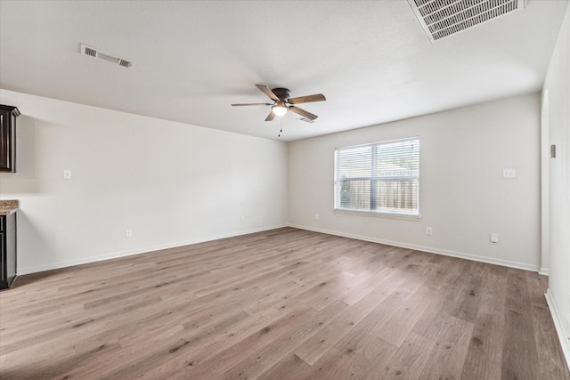 spare room with light wood-type flooring and ceiling fan