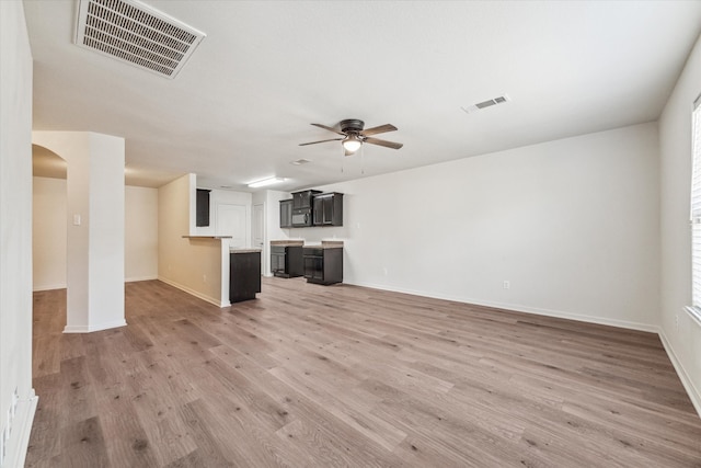 unfurnished living room with light wood-type flooring, ceiling fan, and plenty of natural light