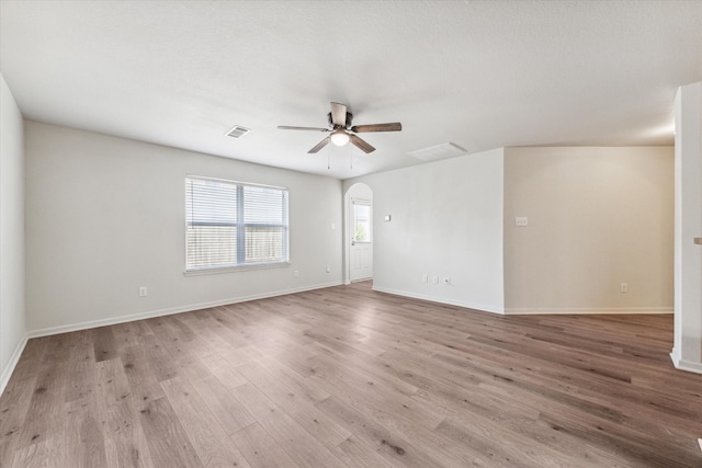 empty room with a textured ceiling, light hardwood / wood-style floors, and ceiling fan