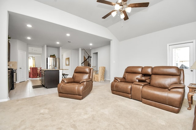 living room featuring vaulted ceiling, ceiling fan, and light colored carpet