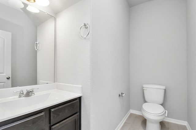 bathroom featuring vanity, tile patterned flooring, and toilet