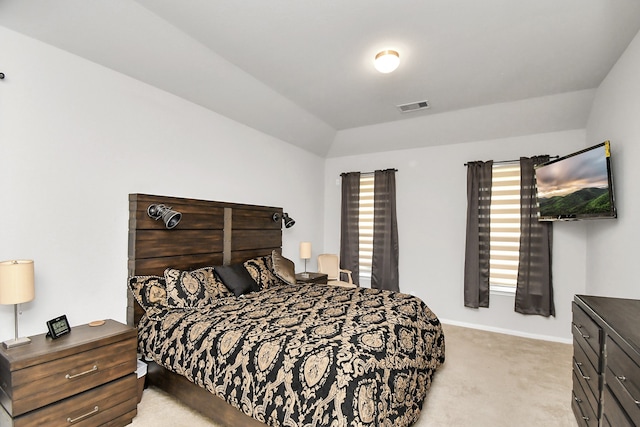 bedroom with light colored carpet and lofted ceiling