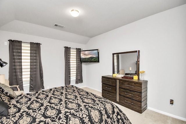 bedroom with light colored carpet and lofted ceiling