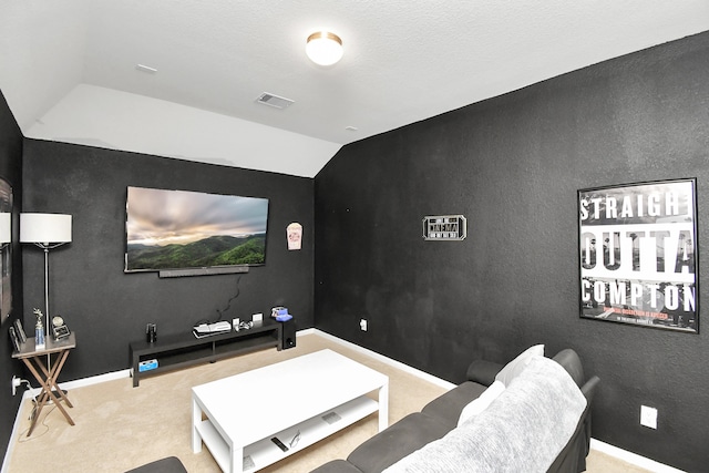 cinema room featuring lofted ceiling and light carpet