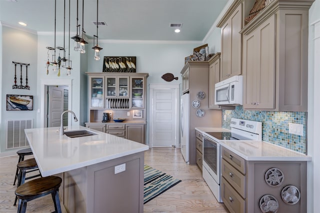 kitchen with light wood-type flooring, white appliances, sink, a center island with sink, and a breakfast bar area