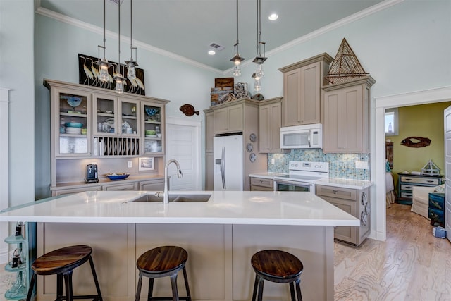 1038 Elizabeth St, Gilchrist, TX 77617 - kitchen featuring white appliances, a sink, a breakfast bar, light countertops, and crown molding