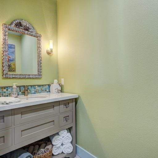 1038 Elizabeth St, Gilchrist, TX 77617 - bathroom featuring vanity, decorative backsplash, and baseboards