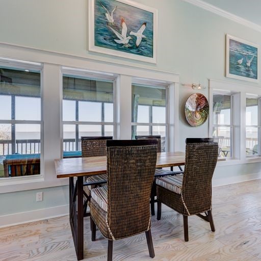 dining area with crown molding, plenty of natural light, and light wood-type flooring