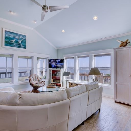 living room with ceiling fan, light wood-type flooring, lofted ceiling, and crown molding