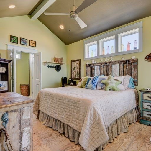 bedroom featuring vaulted ceiling with beams, ceiling fan, and light wood-type flooring