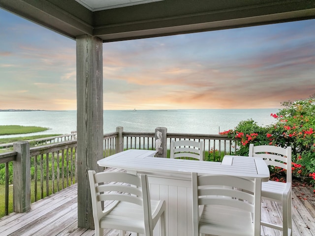 1038 Elizabeth St, Gilchrist, TX 77617 - deck at dusk with outdoor dining area and a water view