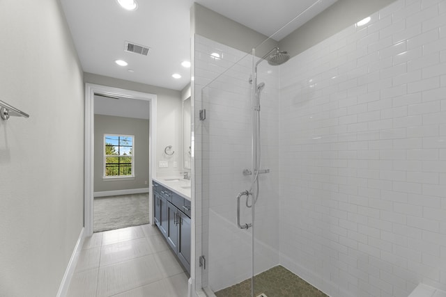 bathroom featuring vanity, a shower with shower door, and tile patterned flooring