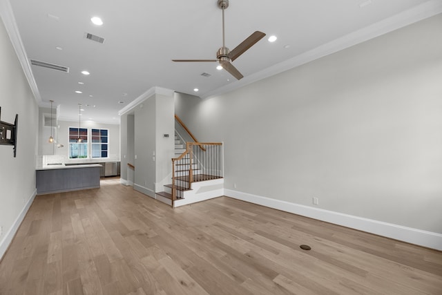 unfurnished living room with light wood-type flooring, ornamental molding, and ceiling fan