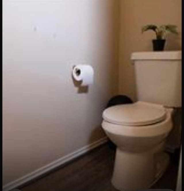 bathroom with hardwood / wood-style flooring and toilet