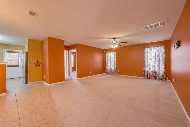 carpeted spare room featuring ceiling fan