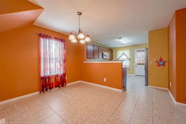 tiled spare room featuring vaulted ceiling, an inviting chandelier, and plenty of natural light