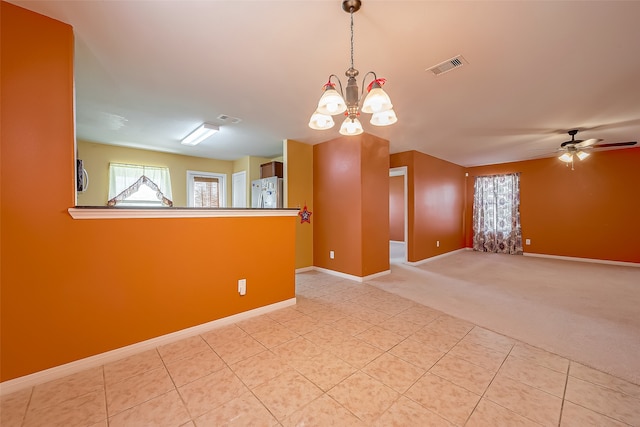 carpeted empty room with ceiling fan with notable chandelier