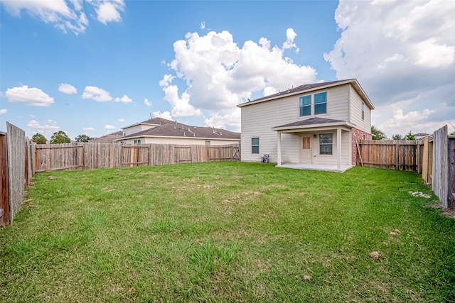 rear view of house with a lawn and a patio