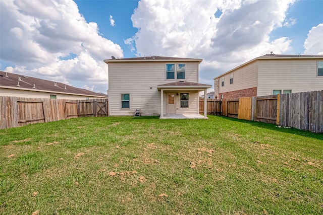 rear view of property featuring a patio and a yard