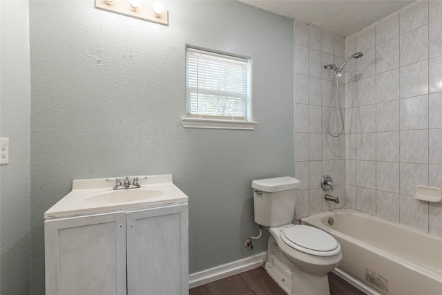 full bathroom featuring wood-type flooring, vanity, toilet, and tiled shower / bath