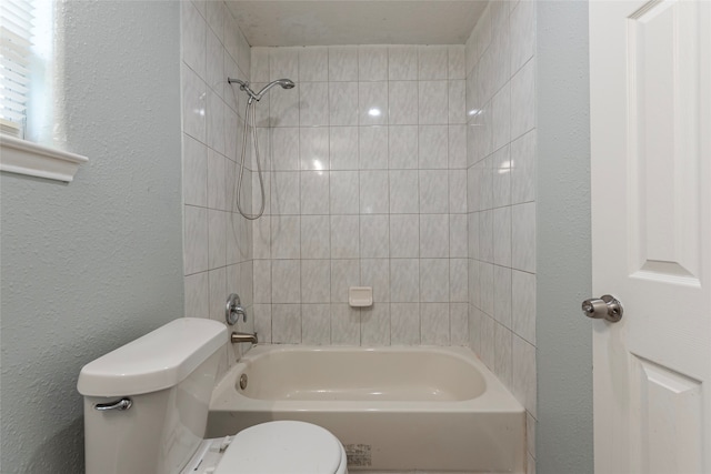 bathroom featuring tiled shower / bath and toilet