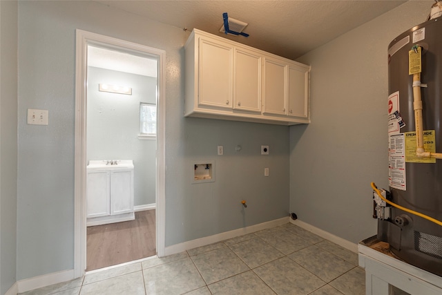 laundry room featuring light tile patterned flooring, cabinets, hookup for a washing machine, water heater, and electric dryer hookup