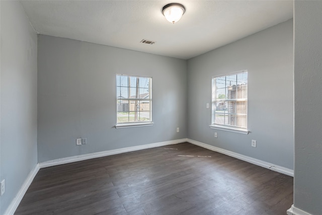 spare room with dark hardwood / wood-style floors