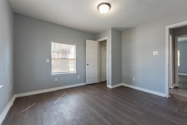 unfurnished bedroom featuring dark hardwood / wood-style floors and a closet