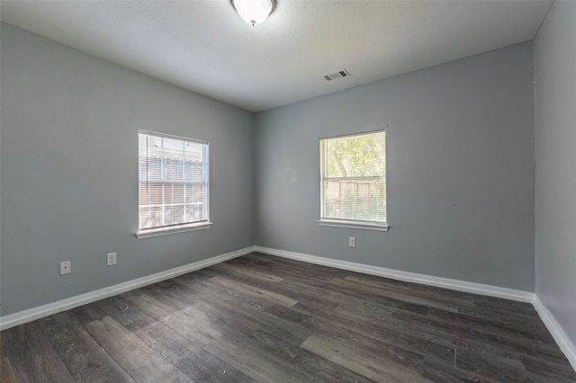 unfurnished room with dark hardwood / wood-style floors and plenty of natural light