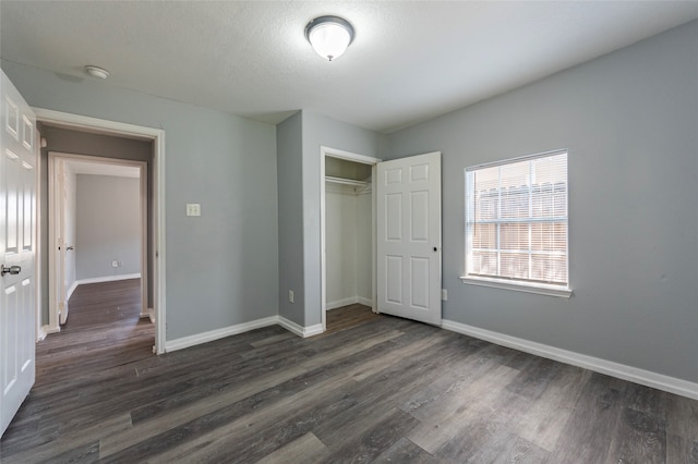 unfurnished bedroom with a closet, dark hardwood / wood-style floors, and a textured ceiling