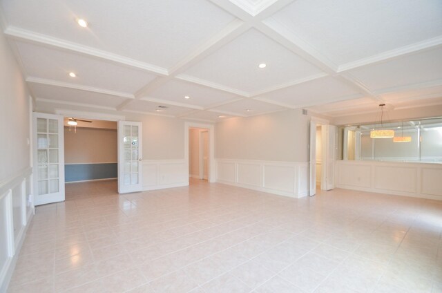 unfurnished room with beamed ceiling, coffered ceiling, and french doors