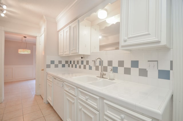 kitchen featuring sink, light tile patterned floors, dishwasher, tile counters, and white cabinets