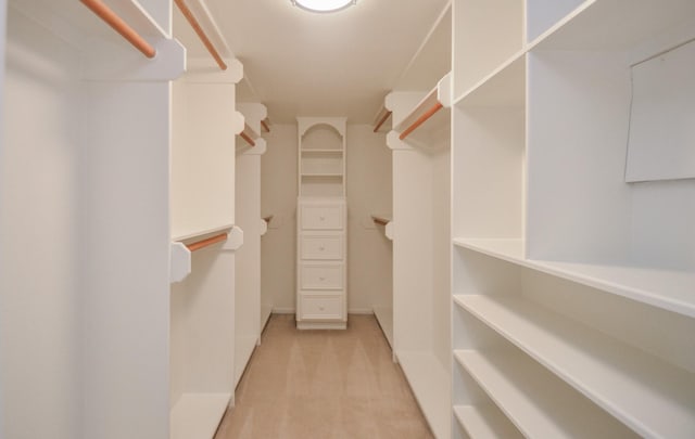 walk in closet featuring light colored carpet