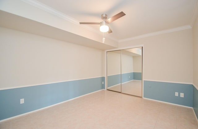 unfurnished bedroom featuring ceiling fan, a closet, baseboards, and crown molding